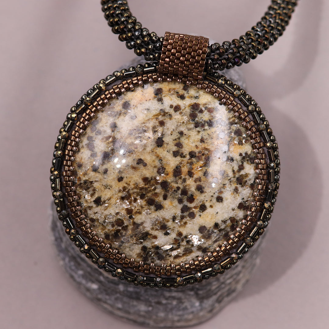 Embroidered necklace with mica schist (mica and garnet)