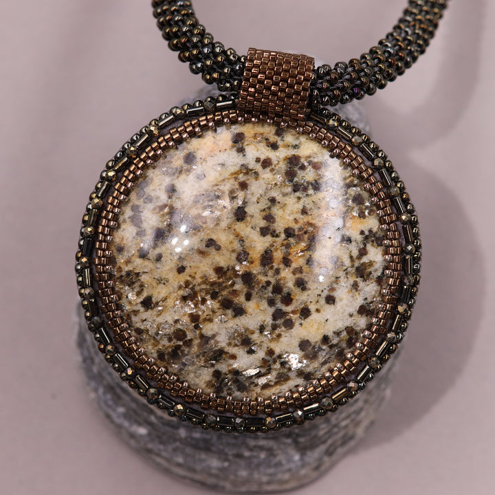 Embroidered necklace with mica schist (mica and garnet)